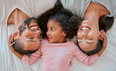 Image showing Happy, love and family relaxing on the bed together in a bedroom of their house to bond and relax. Happiness, smile and parents lying, talking and bonding with their girl child in room at their home.