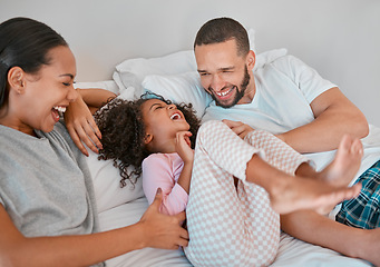 Image showing Family, parents and girl happy on bed, smile, laugh and bonding on weekend. Mom, dad or couple with kid happiness and love in pajamas, morning and being playful, care and fun together in bedroom.