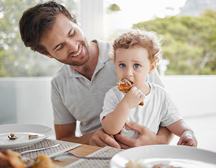 Image showing Father, baby and eating at lunch table for bonding together in family home with hungry child. Food, health and wellness of independent and cute kid eating chicken with proud smile of dad.