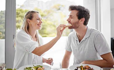 Image showing Couple, food and eating lunch with a woman feeding her man on a romantic date at home at the dining table. Health, nutrition and diet with a husband and wife eating delicious meal or lunch