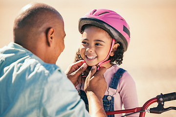 Image showing Bike safety, kid and helmet of a girl with father ready for cycling learning outdoor with a smile. Dad with happy kid putting on safe gear for a bicycle teaching lesson with happiness and care