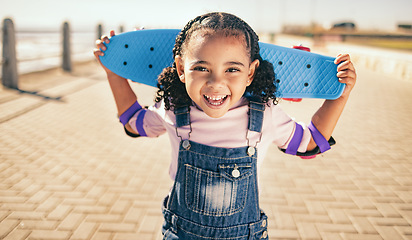 Image showing Child, skateboard and excited for fun activity outdoor on promenade with smile, happiness and energy on summer vacation. Portrait of black girl with safety gear for elbow for skating or skateboarding