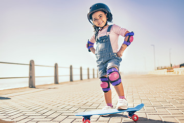 Image showing Summer, happy and little girl portrait with skateboard for holiday in Los Angeles with sky mockup. Vacation, sidewalk and cute black child with helmet ready to skate for wellness, health and fun.