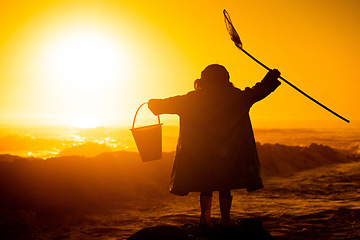 Image showing Silhouette, sunset and child at beach with toys for travel, holiday and playing by water in Australia. Earth day, ocean and back of girl kid in the dark during sunrise to play and relax on vacation