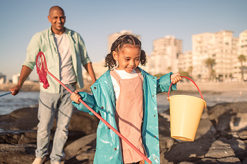 Image showing Fishing, bonding and child with father at beach for adventure, happy and holiday in Australia. Nature, catch fish and girl on vacation with dad for conservation on the rocks by the sea with a smile