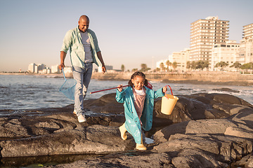 Image showing Father, girl and fishing at beach, learning and happy together outdoor in summer, bonding or fun on rocks. Black man teaching kid to catch fish, rod and bucket with family at a ocean, sea and nature