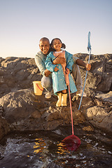 Image showing Father, girl or bonding and fishing by beach, ocean or sea rock pools with plastic bucket and nets on summer holiday. Portrait, smile or happy child or kid with man catching fish, shrimp or muscles