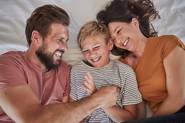 Image showing Top view, parents or boy bonding in tickle game on house, family home or hotel bed in trust, love or security. Smile, happy man or laughing woman and son, comic child or preteen kid in funny activity