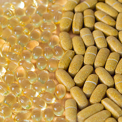 Image showing Fish oil capsules and multivitamin tablets on a table