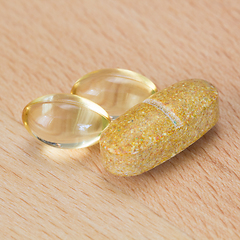 Image showing Fish oil capsules and multivitamin tablet on a table