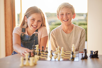 Image showing Kids, chess and board game in portrait in house for learning, strategy and happy development together. Children, girl and brother with smile, happiness and family games at table in home living room