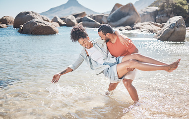 Image showing Love, water and playful black couple at the beach enjoy summer vacation, holiday and weekend. Travel, nature and man carrying woman standing in ocean having fun, bond and spend quality time together