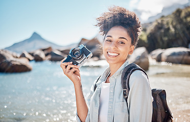 Image showing Travel, beach and camera with a black woman tourist taking a photograph by the sea or ocean water in summer. Nature, portrait or photographer with a female outdoor on holiday or vacation by the coast