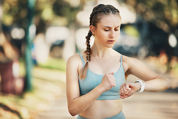 Image showing Fitness, watch time and workout of a woman training and checking heart pulse in a outdoor park. Runner wellness, steps and smart watch technology app after running, exercise and sport health