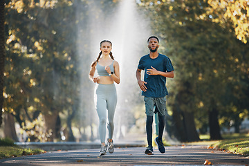 Image showing Couple running, fitness and runner in park for exercise and cardio with body training outdoor. Interracial, black man and woman run in nature, workout and sports for healthy active lifestyle.