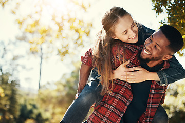 Image showing Love, couple and piggy back in nature on vacation, holiday or date outdoors. Romance, diversity and happy man carrying woman on shoulders, having fun or enjoying quality time together at park outside