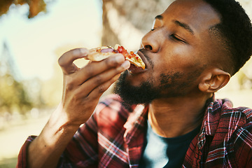 Image showing Fast food, hungry and black man eating pizza for delicious and yummy lunch break in park. Gen z, food and hunger of young person enjoying carbs pizza slice meal with satisfied face.