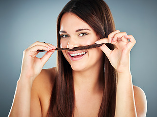 Image showing Hair care, shine and portrait of a salon woman with comic self care against a blue studio background. Beauty, smile and funny hair model with cosmetics from luxury hair salon keratin treatment