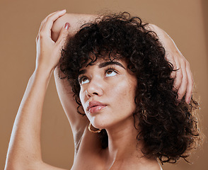 Image showing Curly hair, woman and freckles, beauty and makeup for glow, shine and hair care on studio background. Young girl model, melasma face and natural cosmetics, clean skincare and dermatology aesthetics