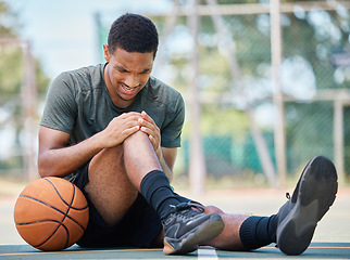 Image showing Basketball court, man and injury, knee pain and joint pain, fitness emergency and first aid accident, risk and bone health. Black man, basketball player and leg pain, muscle inflammation and problem