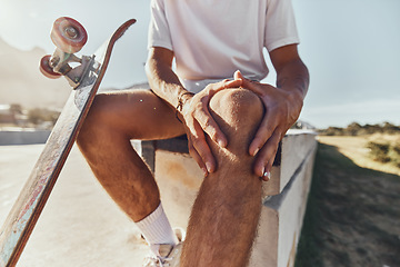 Image showing Knee injury, skateboard and urban city skate park accident with a man with knee pain after workout. Leg pain after sport, fitness and athlete exercise with hands holding a muscle inflammation