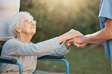 Image showing Elderly woman, wheelchair and caregiver holding hands for support, care and solidarity in nature park. Senior person, patient disability and healthcare nurse communication in retirement home outdoor