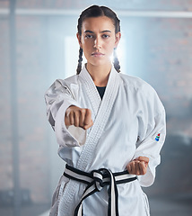 Image showing Woman, karate and punching pose in taekwondo fitness, workout or training for black belt competition, fight challenge or self defense. Portrait, martial arts and judo sports person in power exercise