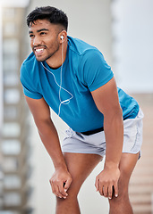Image showing Fitness, rest and runner stop to relax or breathe on outdoor run or workout with headphones. Health, training and wellness, a tired sports man on break from running exercise while streaming music app