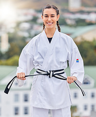 Image showing Karate, ready and portrait of a woman training on a rooftop for professional event, competition and fight. Black belt, fitness and taekwondo girl with a smile for sports, body power and martial arts