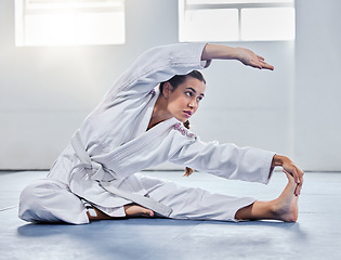 Image showing Martial arts, karate or woman stretching before training practice, fitness workout or challenge competition. Girl, warrior or taekwondo fighter warm up for dojo self defense or safety security lesson