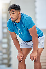 Image showing Tired, fitness and sweat with earphones music for cardio, workout and athletic training break. Exercise, exhausted and sweaty indian man listening to audio streaming on outdoor athlete rest.