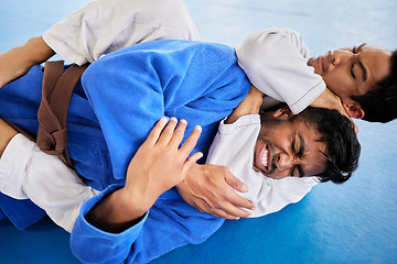 Image showing Men, martial arts and karate choke hold in dojo to practice fighting skill. Training, taekwondo and fitness class for self defense, workout or exercise challenge with people in match or competition.