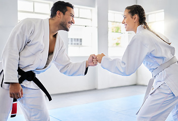 Image showing Karate, motivation and fist bump with a man and woman fighter training together in a gym or dojo. Fitness, exercise and fight with a male and female athlete in a health club for combat sports