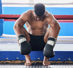 Image showing Boxer, martial arts and man tired and sad after boxing or sports competition mistake, failure or stress, anxiety and depression pre workout. Athlete man worried about exercise or fight at boxing ring