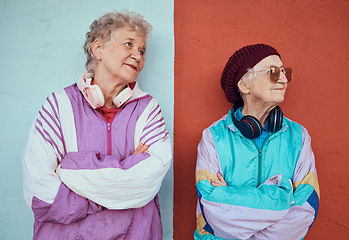 Image showing Fashion, headphones and senior women in city with blue and red wall background model for urban style. Freedom, music and elderly females relax on weekend in trendy, cool and modern outfit in town