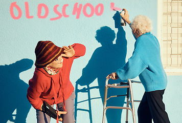 Image showing Senior women, friends and spray paint for vandalism, graffiti and street art to spray old school on nursing home building wall and keep watch. Crazy old people break law with illegal activity outdoor