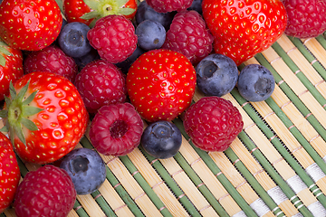 Image showing Variety of berries - trawberries, blueberries, raspberries scattered