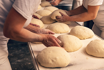 Image showing Bakers forming bread dough in a bakery