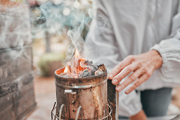 Image showing Agriculture, fire and hands of a beekeeper in production of honey with smoke in container. Sustainability, eco friendly and business owner with a smoking pot for start of honeycomb farming in nature