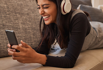 Image showing Smartphone, headphones and woman on sofa listening to music, watch online video chat or mobile app zoom call. Excited, relax and music of a youth girl audio, podcast or online subscription streaming