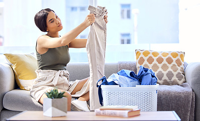 Image showing Laundry, housekeeping and woman folding clothes, cleaning and working in the living room of her house. Routine, washing and cleaner with clean clothing in a basket on the sofa of the home lounge