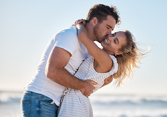 Image showing Love, dating and couple kiss at beach enjoying summer holiday, vacation and honeymoon by the sea. Travel, romance and man and woman show affection, embrace and bonding in nature on weekend together