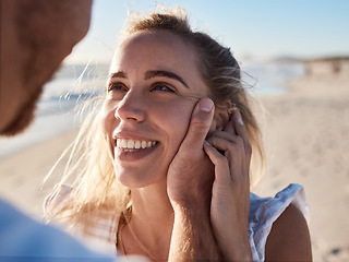 Image showing Woman, face and man hand for love, support and care, together on beach and holiday in summer. Couple, trust and happy relax vacation for honeymoon, quality time or marriage with husband holding wife
