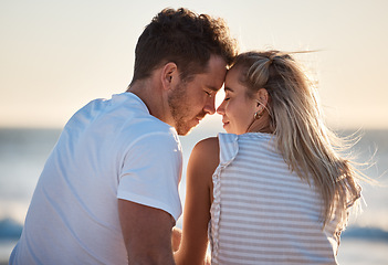 Image showing Love, beach and couple with head together enjoying romantic holiday, honeymoon and vacation together. Summer, travel and man and woman sitting by ocean bonding, faces touching and show affection