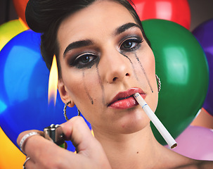 Image showing Crying woman, cigarette and balloons with psychology, mental health and depression problem with lighter flame for smoking. Face of a female feeling sad, anxiety and stress at a party for broken heart