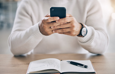 Image showing Closeup, man typing and phone in office for communication, social media or email on web app. Hands, smartphone and chatting at workplace with book on desk for planning, research and digital marketing