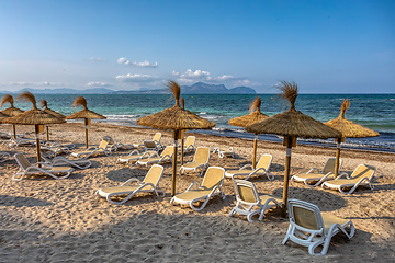 Image showing Can Picafort Beach with straw umbrellas and sun loungers, Can Picafort, Balearic Islands Mallorca Spain.