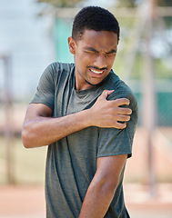 Image showing Fitness, man and shoulder pain by runner after exercise, training and morning run in city on blurred background. Arm injury, sport and athletic guy suffering from muscle, arthritis or cardio distress