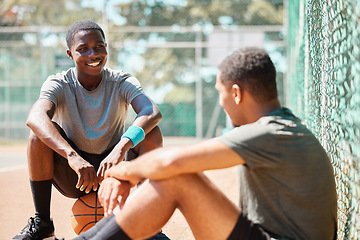 Image showing Basketball, sport and athlete friends talk after training, exercise and sports outdoor. Game conversation on the basketball court ground talking about team strategy on a relax break from fitness