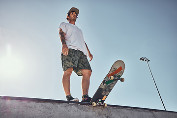 Image showing Sports, skater and low angle of man on ramp preparing for action stunt, trick or practice in city. Thinking, skateboarding and male skateboarder getting ready for training or workout at a skate park